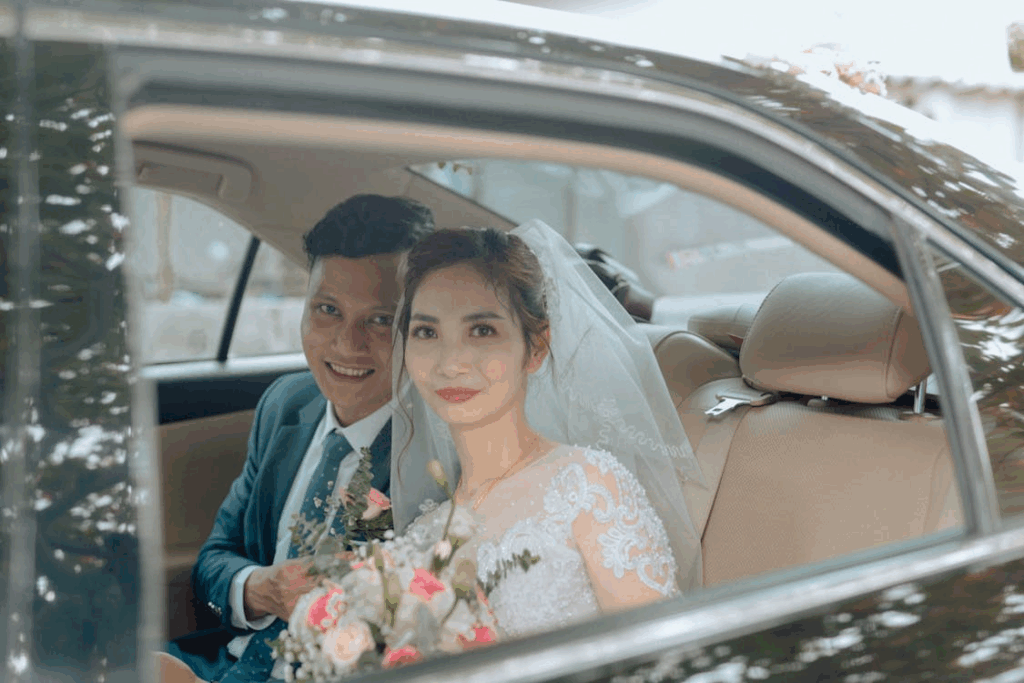 A bride and groom inside a luxury car.