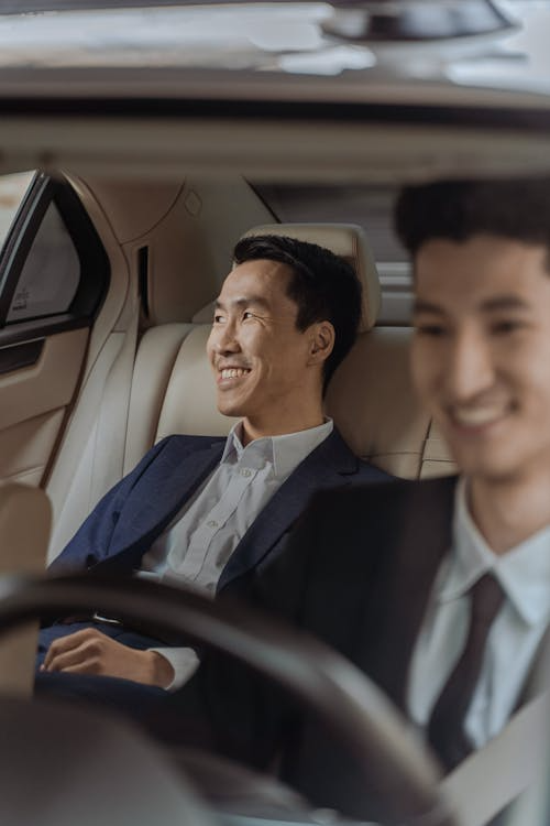 A passenger smiles in his comfortable luxury car.