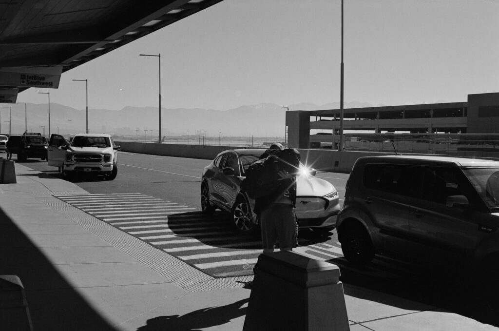 A row of cars at an airport pickup.