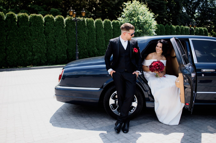 A couple standing in front of a car