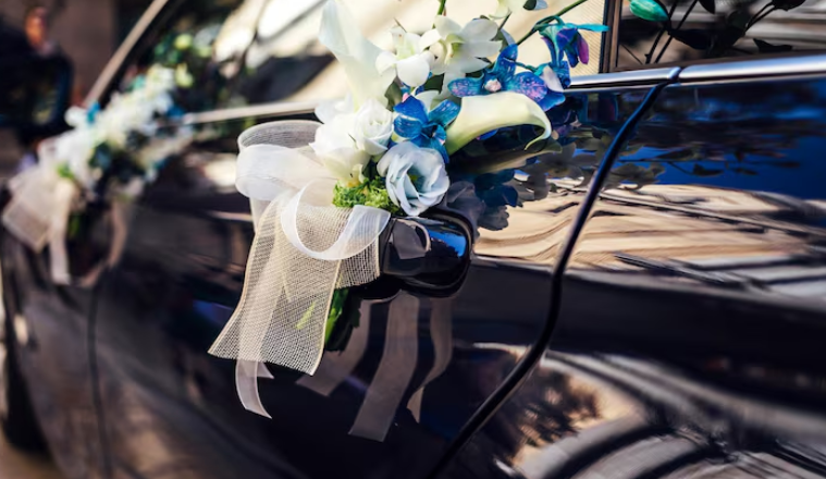 Floral wedding decoration attached to the door handle of a luxury car