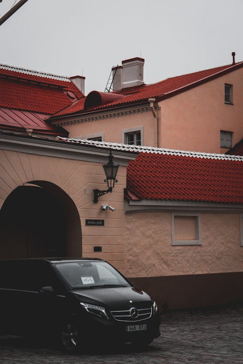 A black Mercedes Benz van parked near a house