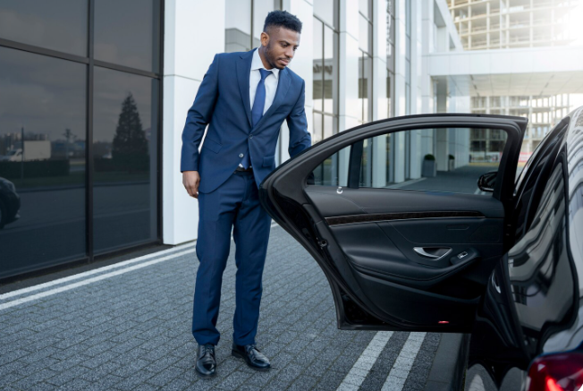 Elegant chauffeur opening car door for luxury private car service during Stagecoach festival transport