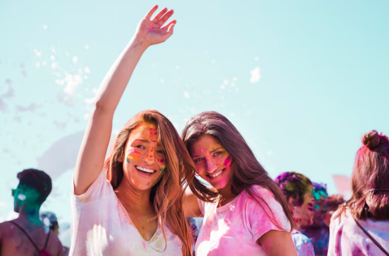 Smiling young women enjoying music festival atmosphere outdoors