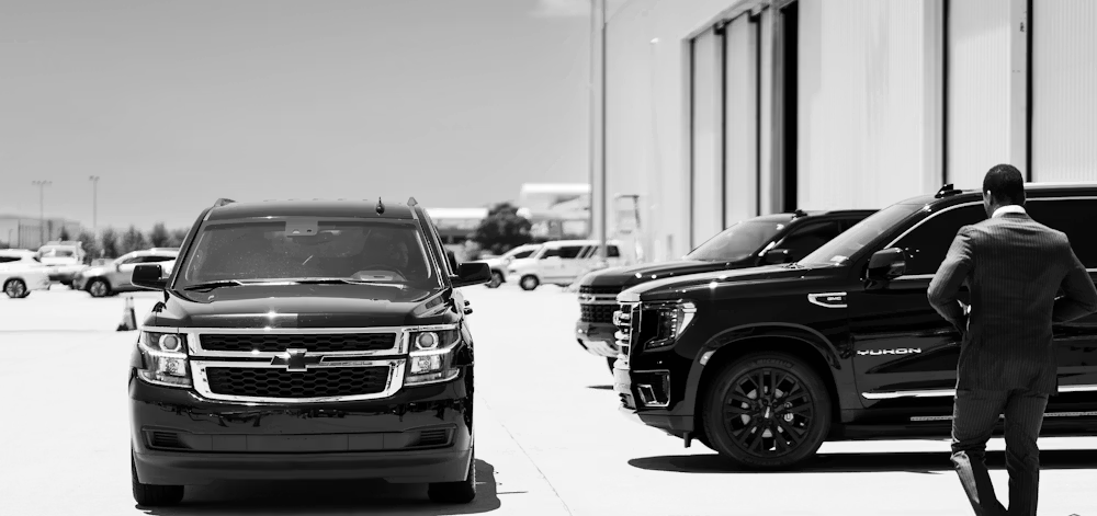 A man walking to a black SUV in a parking lot