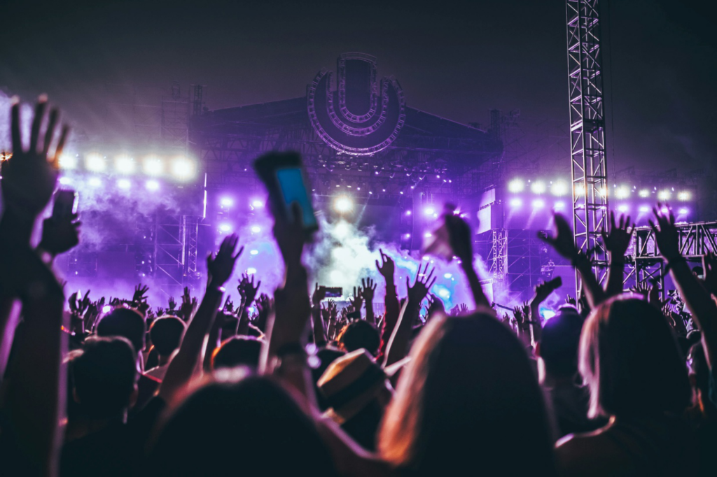 People at a music festival in front of a stage 