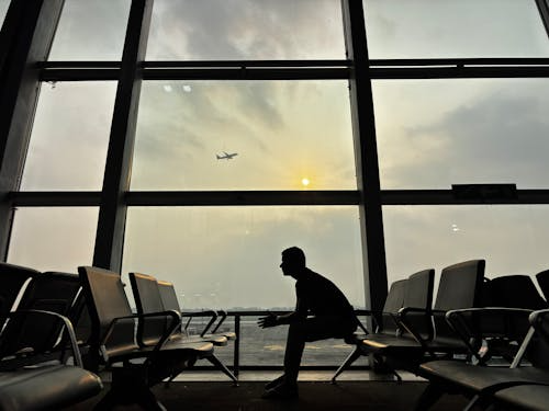 Frustrated traveler sitting in an airport terminal after missing a flight